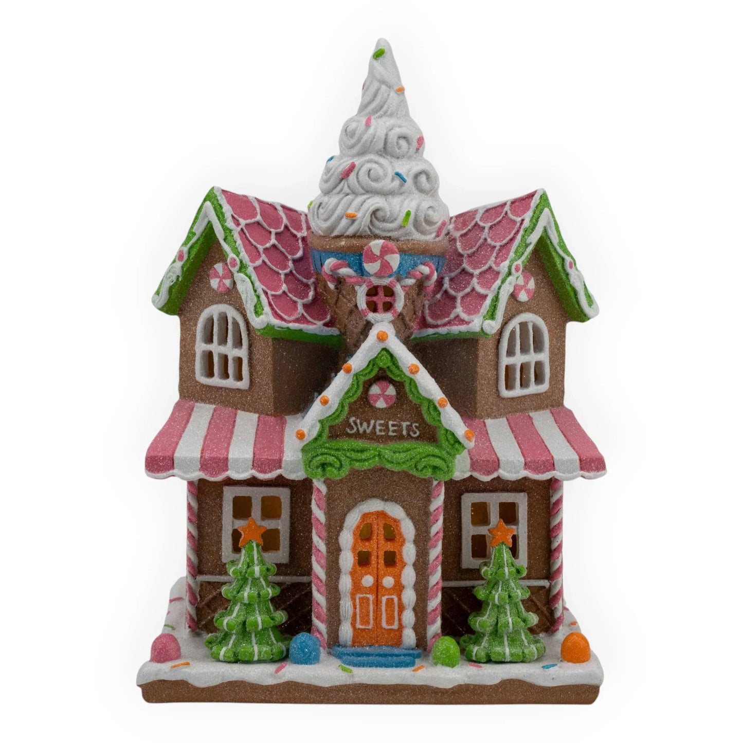 Gingerbread sweets shop with candy canes, pink roof, and ice cream cone tower, festive holiday décor