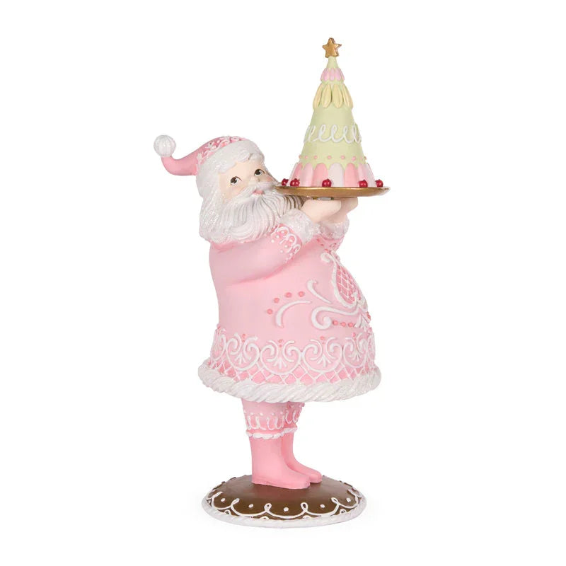 Pink Santa figurine holding a pastel Christmas tree cake, festive holiday décor