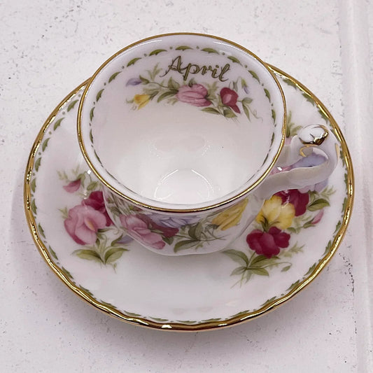 Elegant April floral teacup and saucer set with gold trim, vintage home décor