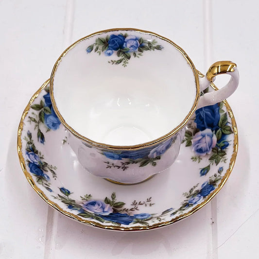Elegant porcelain teacup and saucer with blue roses and gold trim, vintage-style home décor