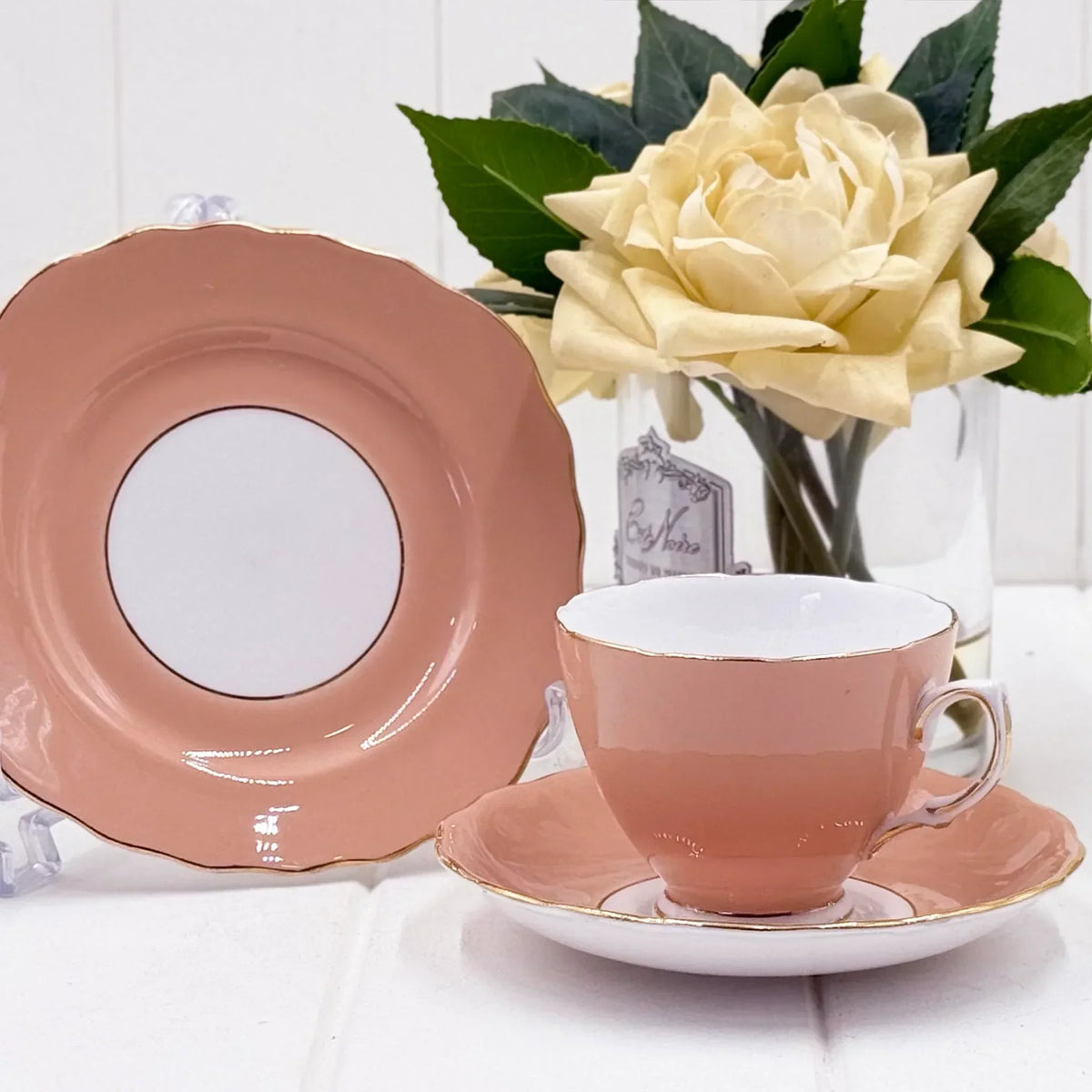 Pink porcelain teacup and saucer set with gold trim, vintage-style home décor beside white rose