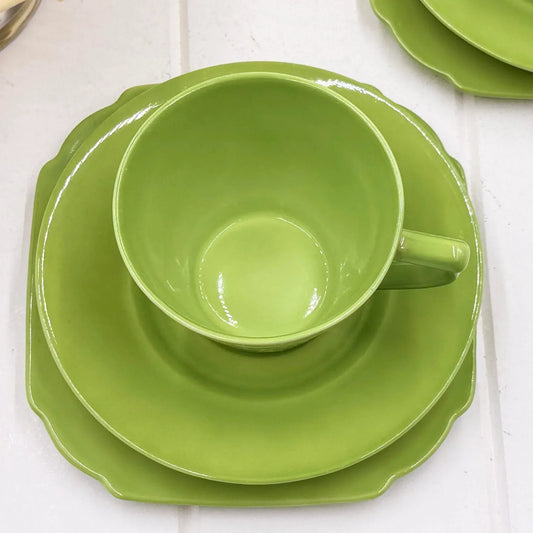 Vibrant green ceramic dinnerware set with scalloped edges, perfect for elegant table settings and home décor.