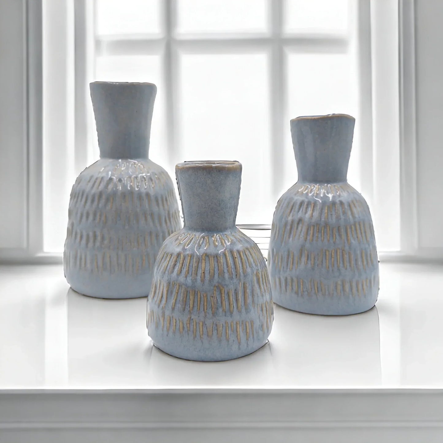 Set of three light blue textured ceramic vases with gold accents, perfect for modern home dƩcor styling.
