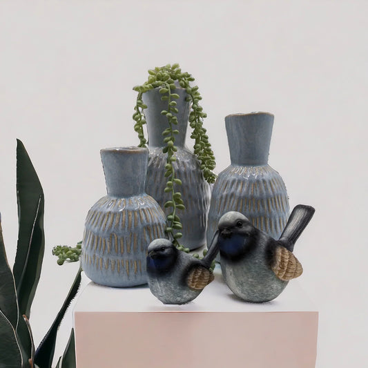 Blue ceramic vases with textured glaze, decorative birds, and trailing succulent for modern home dƩcor