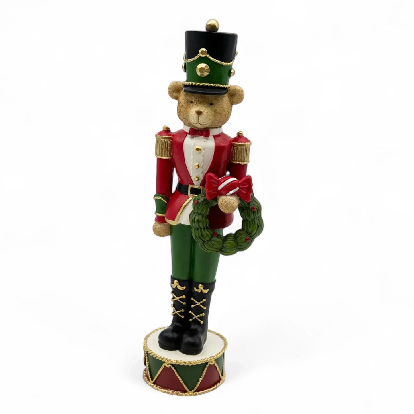 Festive teddy bear nutcracker in red and green uniform holding wreath, holiday home decor