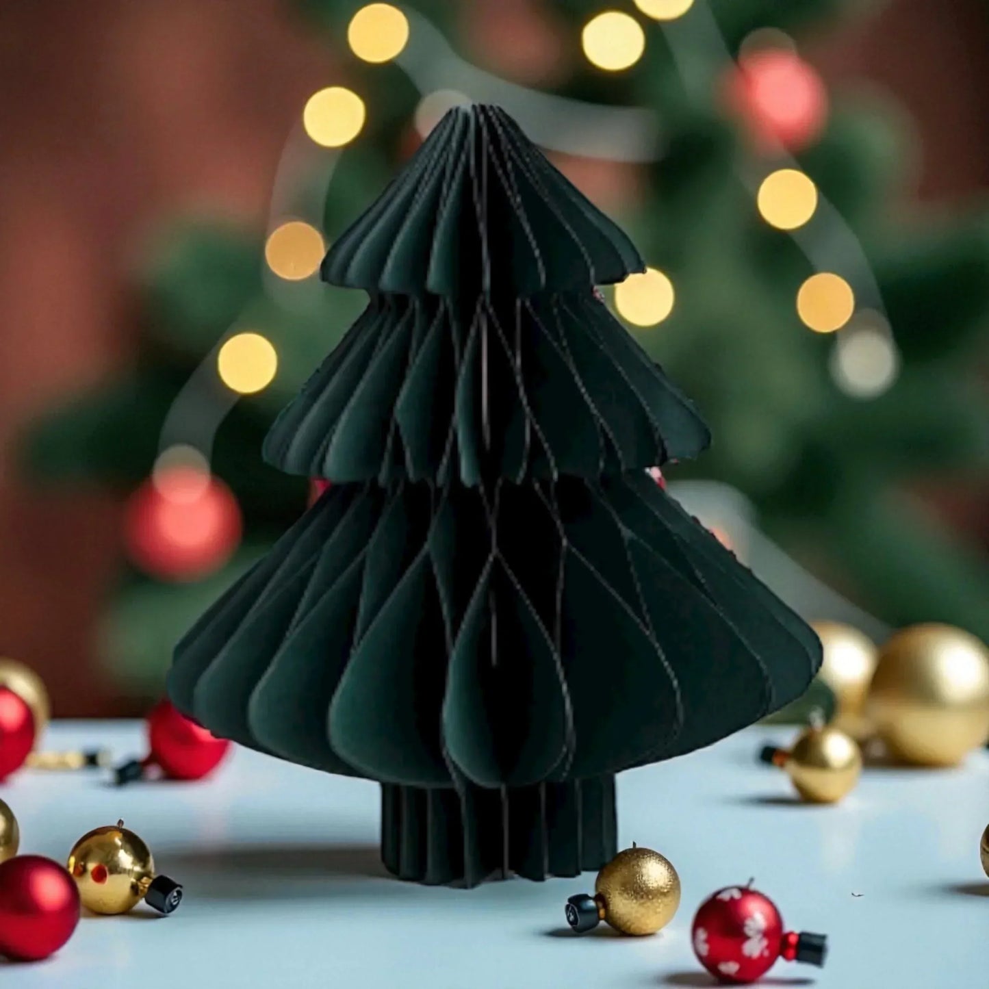 Modern black paper Christmas tree decoration with red and gold ornaments, festive holiday home dรฉcor
