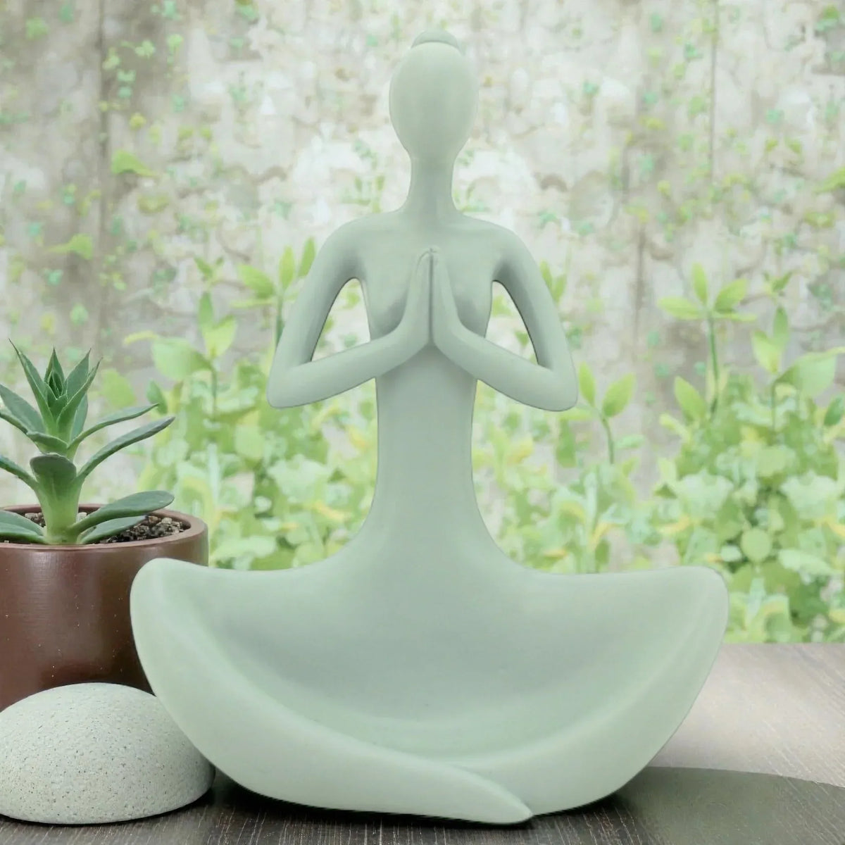 Sage green meditation figurine for zen home décor, styled with succulent and stone