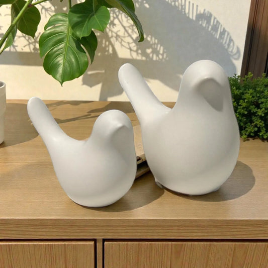 White ceramic bird sculptures for modern home dƩcor, styled on wooden shelf with green plants