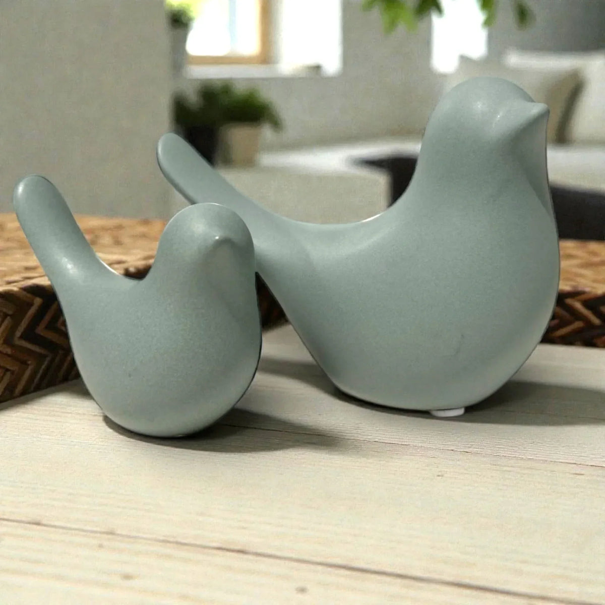 Sage green ceramic bird figurines for modern home décor, styled on wooden surface with woven mat