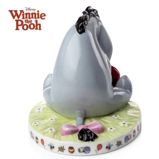 Disney Winnie the Pooh Eeyore porcelain figurine with pink bow, floral base, and honey pot details