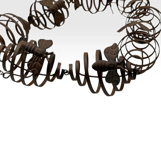 Rustic metal bee wreath with coiled wire design, perfect for vintage home décor and garden accents.
