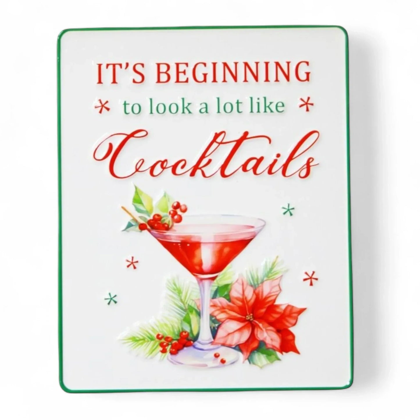 Festive holiday sign with 'It's Beginning to Look a Lot Like Cocktails' text, martini glass, poinsettia, and holly decor
