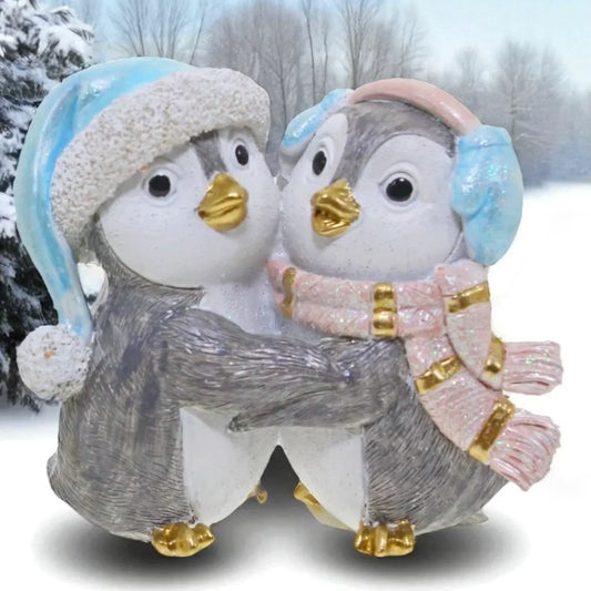 Cute penguin figurine couple in winter hats and scarves, festive home décor for snowy season