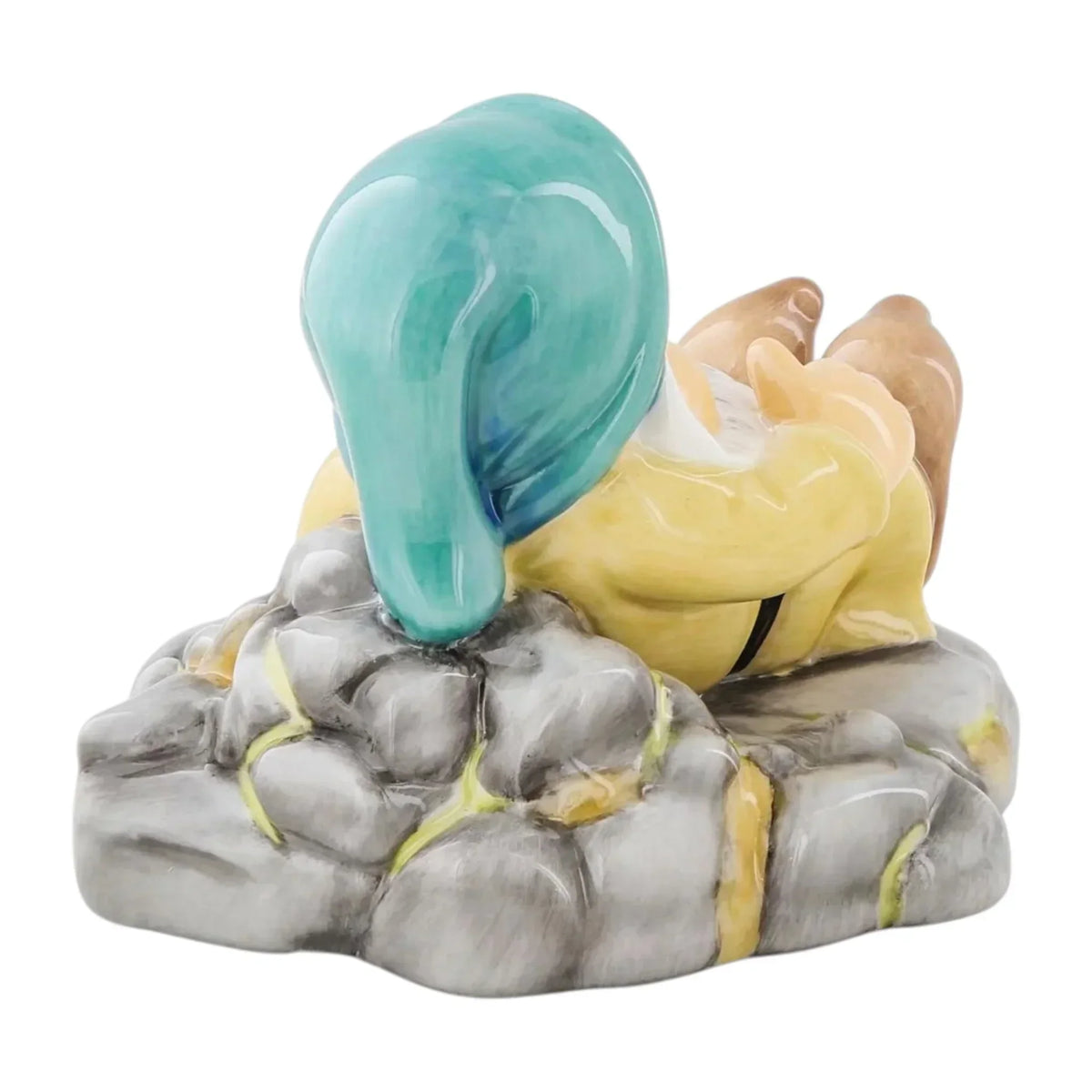 Ceramic figurine of a duck with turquoise head, yellow body, resting on grey rocks, home décor accent piece