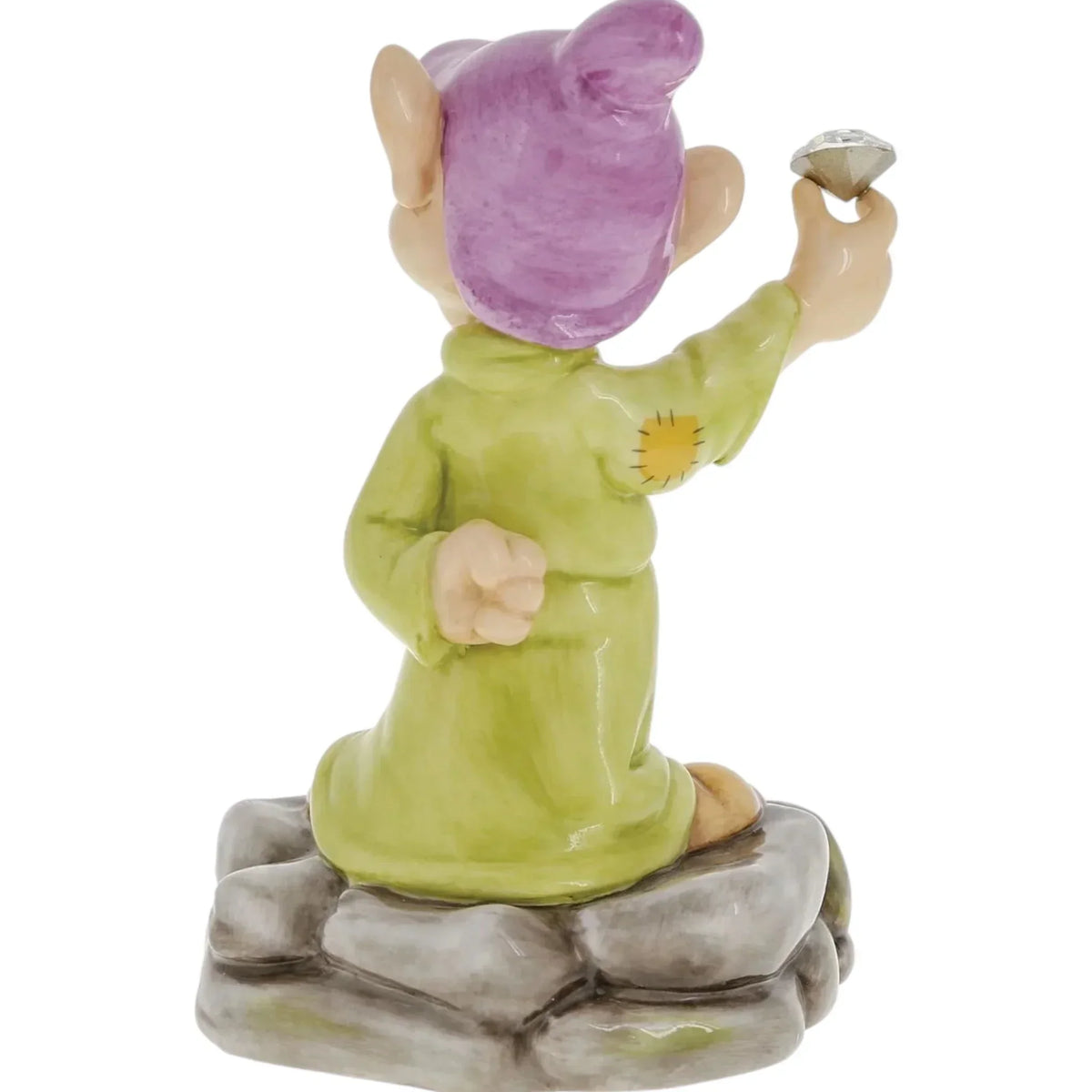 Ceramic gnome figurine in green robe and purple hat, holding a gem, perched on stone base for home décor