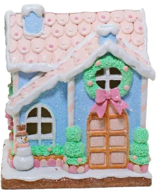 Pink and blue gingerbread house with wreath, snowman, and festive decorations for holiday home décor