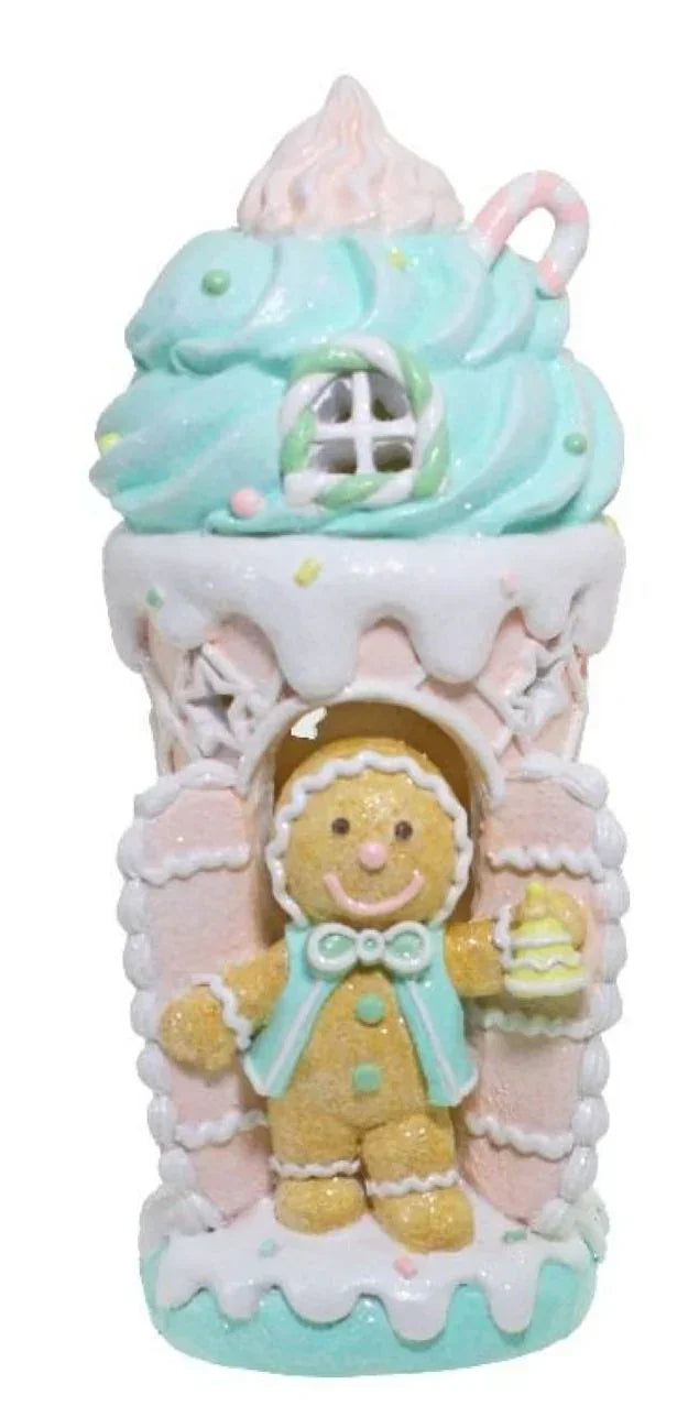 Gingerbread man figurine in pastel candy house, festive holiday décor with mint frosting and sprinkles
