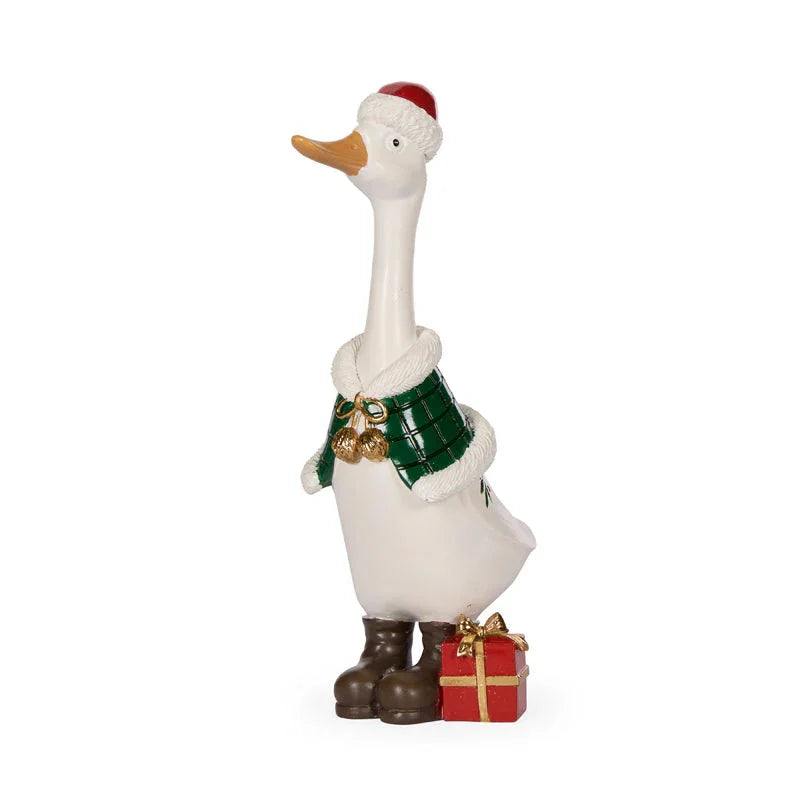 Festive white duck figurine wearing Santa hat, plaid scarf, boots, holding gift box — holiday home décor