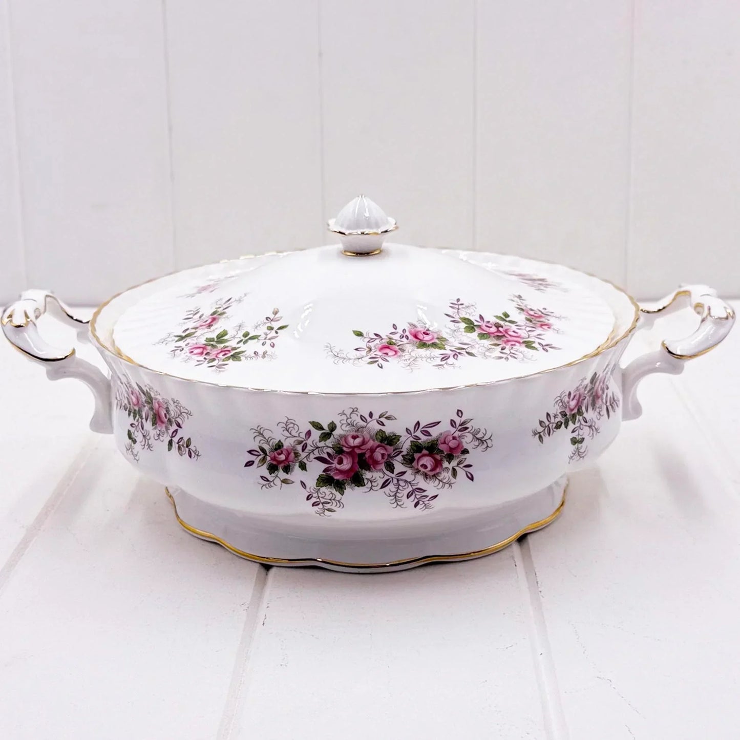 Elegant white porcelain tureen with pink rose floral pattern, gold trim, and ornate handles for vintage home décor