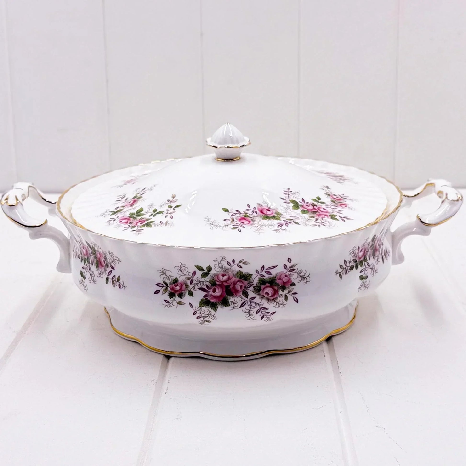 Elegant white porcelain tureen with pink rose floral pattern, gold trim, and ornate handles for vintage home décor
