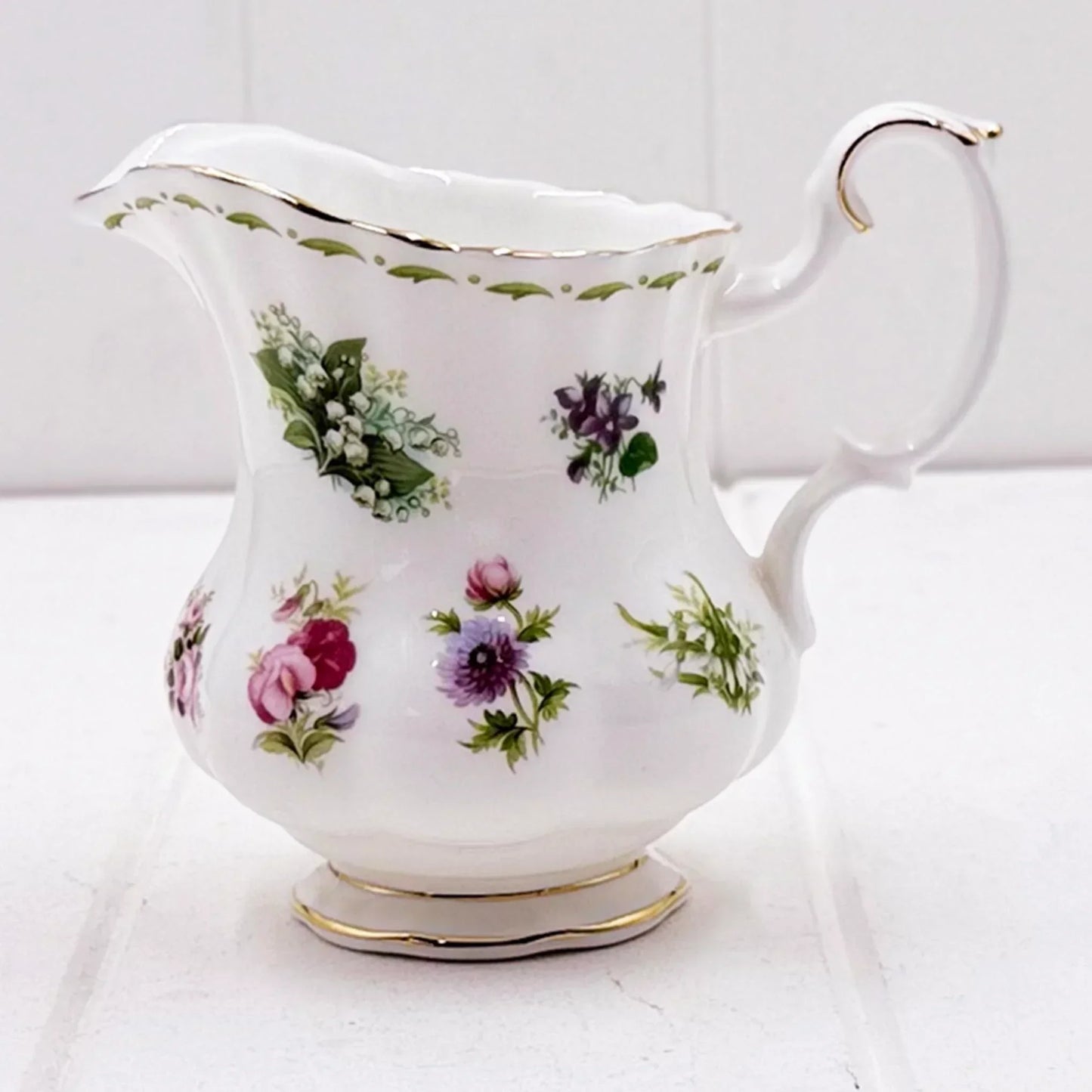 Elegant floral porcelain creamer with gold trim, vintage home décor accent piece