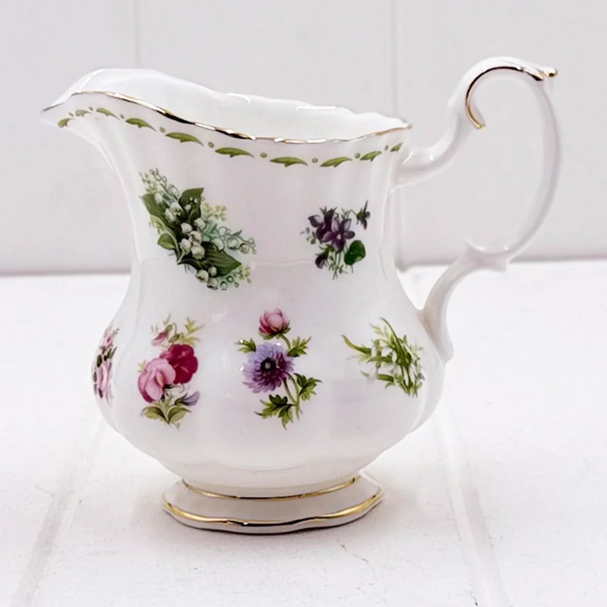 Elegant floral porcelain creamer with gold trim, vintage home décor accent piece
