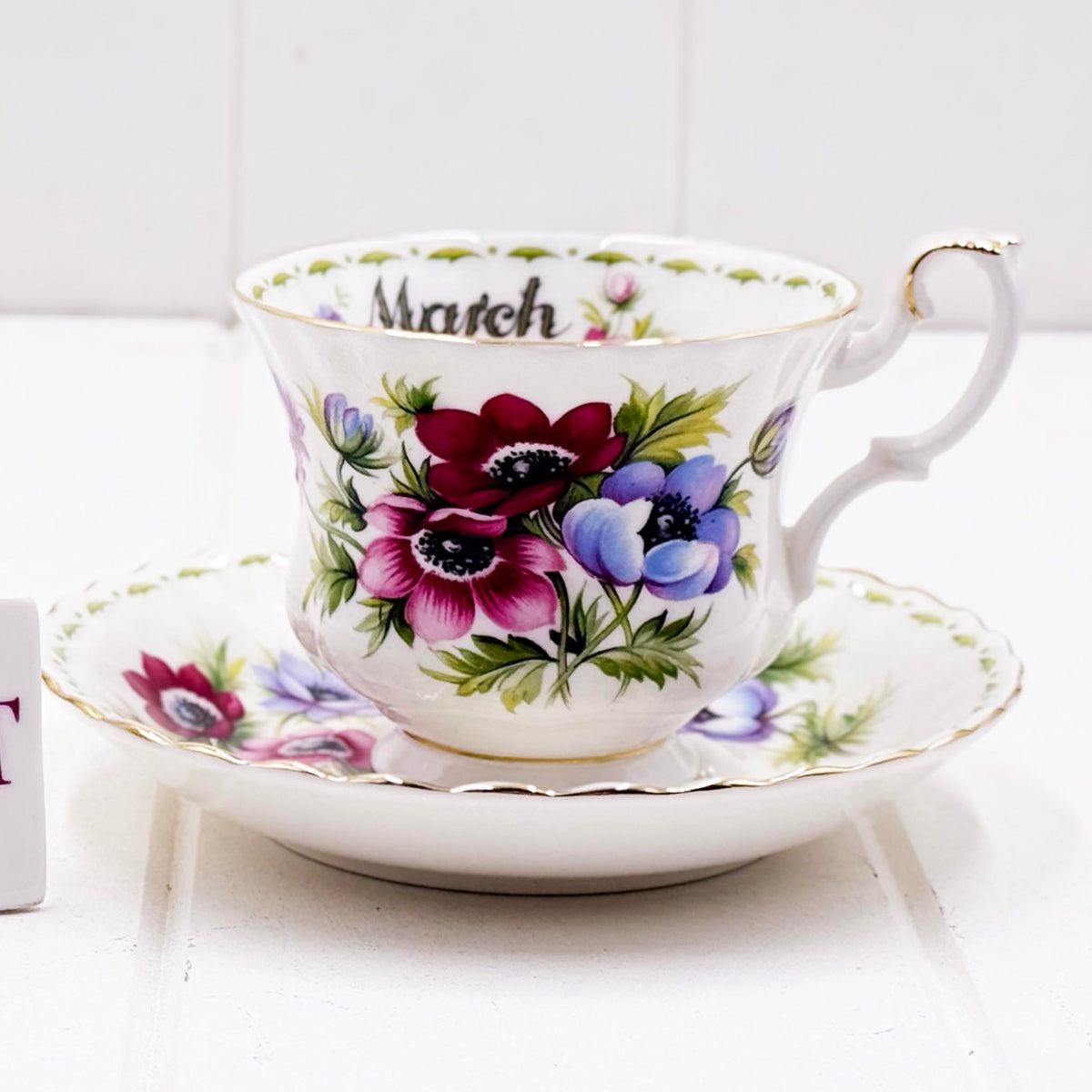 Royal Albert Flower of the Month March Anemones teacup and saucer, showing bold crimson, pink and blue-purple anemones with gold trim